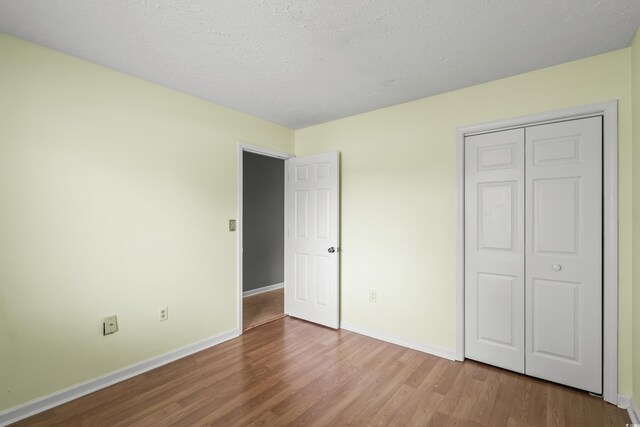 4101 Pinehurst Cir Unit Aa-3, Little River, SC 29566 - unfurnished bedroom featuring wood finished floors, baseboards, a closet, and a textured ceiling