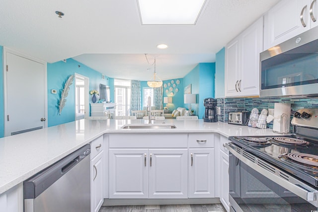161 Sea Watch Dr Unit 601, Myrtle Beach, SC 29572 - kitchen featuring stainless steel appliances, white cabinetry, open floor plan, recessed lighting, and pendant lighting