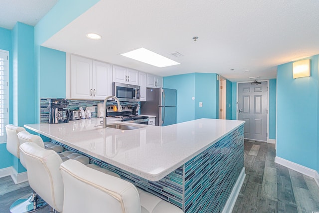 161 Sea Watch Dr Unit 601, Myrtle Beach, SC 29572 - kitchen featuring appliances with stainless steel finishes, dark wood finished floors, a peninsula, recessed lighting, and white cabinetry