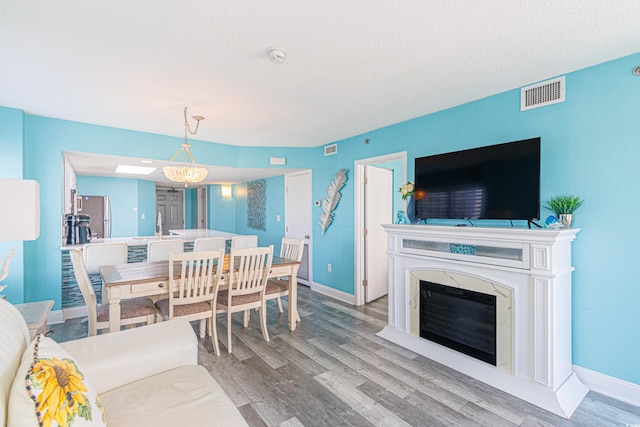 161 Sea Watch Dr Unit 601, Myrtle Beach, SC 29572 - dining room featuring wood finished floors, a textured ceiling, and a high end fireplace