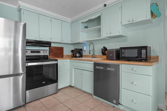5409 N Ocean Blvd Unit 100, North Myrtle Beach, SC 29582 - kitchen with stainless steel appliances, under cabinet range hood, a sink, open shelves, and ornamental molding