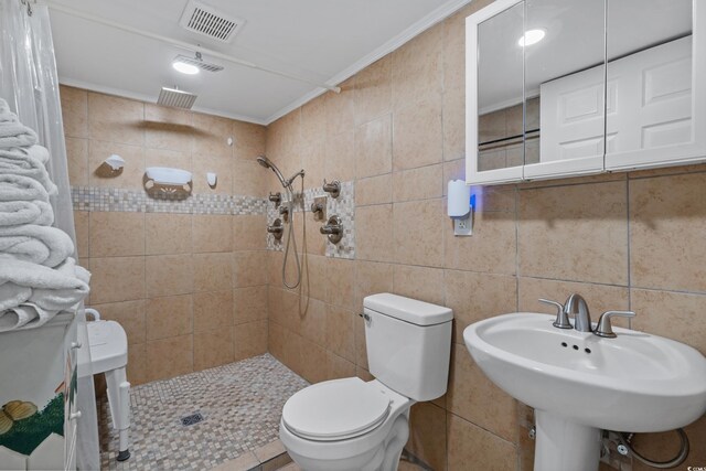 5409 N Ocean Blvd Unit 100, North Myrtle Beach, SC 29582 - bathroom featuring tile walls, a tile shower, toilet, a sink, and crown molding