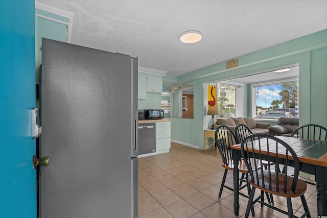 5409 N Ocean Blvd Unit 100, North Myrtle Beach, SC 29582 - kitchen with light tile patterned floors, stainless steel appliances, open floor plan, and white cabinetry
