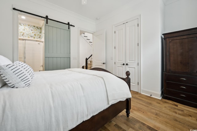 346 Tuckers Rd Unit A, Pawleys Island, SC 29585 - bedroom with wood finished floors, baseboards, a barn door, a closet, and ornamental molding