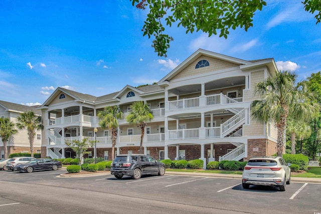 6015 Catalina Dr Unit 732, North Myrtle Beach, SC 29582 - view of building exterior with stairs and uncovered parking