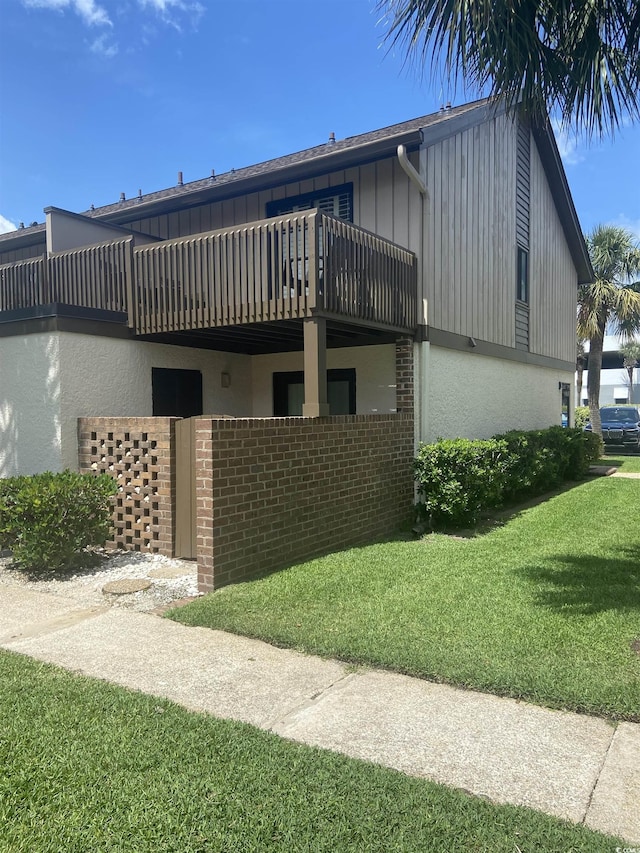 10200 Lake Shore Dr Unit 4, Myrtle Beach, SC 29572 - view of side of property with a balcony, stucco siding, and a lawn