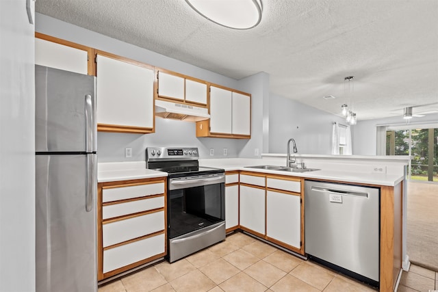 820 Fairway Dr Unit 1502Hh, Longs, SC 29568 - kitchen with stainless steel appliances, under cabinet range hood, a textured ceiling, a peninsula, and light countertops