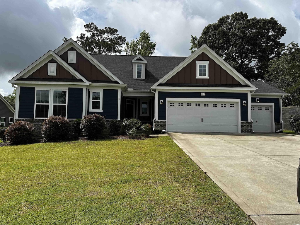 177 Board Landing Cir, Conway, SC 29526 - craftsman-style home featuring an attached garage, a front lawn, board and batten siding, driveway, and roof with shingles
