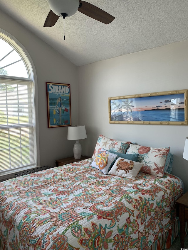 1432 Seahouse Ct, Surfside Beach, SC 29575 - bedroom featuring a textured ceiling, multiple windows, lofted ceiling, and ceiling fan
