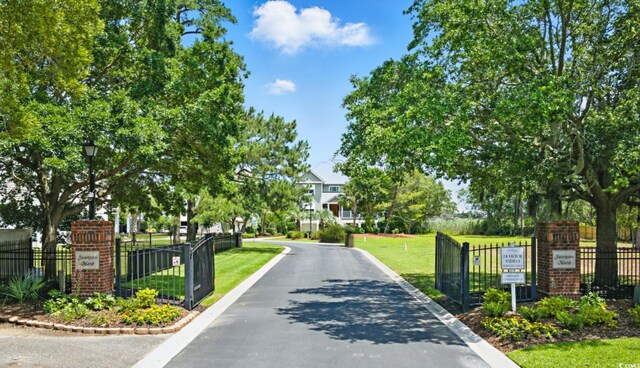 191 Grackle Ln, Pawleys Island, SC 29585 - view of asphalt street featuring street lighting, curbs, and a gated entry