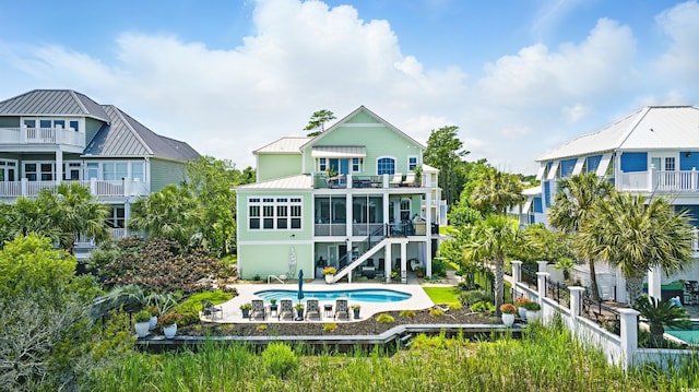 191 Grackle Ln, Pawleys Island, SC 29585 - back of property with a balcony, a patio area, a fenced backyard, an outdoor pool, and stairway