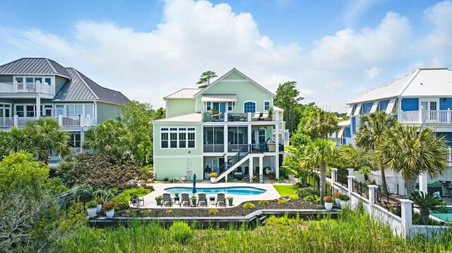 191 Grackle Ln, Pawleys Island, SC 29585 - back of property featuring a balcony, a patio area, a fenced backyard, an outdoor pool, and stairs