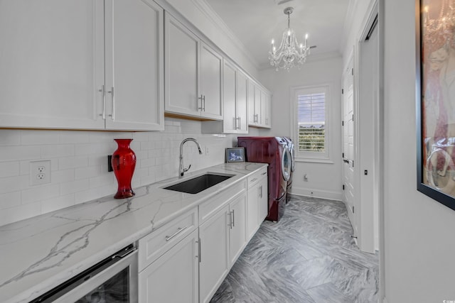 191 Grackle Ln, Pawleys Island, SC 29585 - washroom with washer and dryer, a chandelier, ornamental molding, beverage cooler, and light marble finish floors