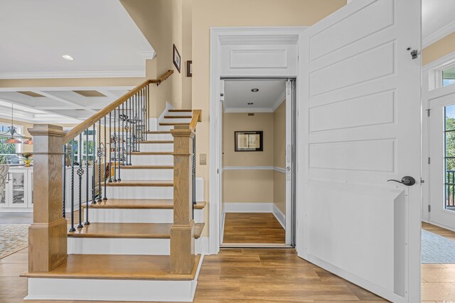 191 Grackle Ln, Pawleys Island, SC 29585 - staircase featuring crown molding, wood finished floors, coffered ceiling, beam ceiling, and recessed lighting