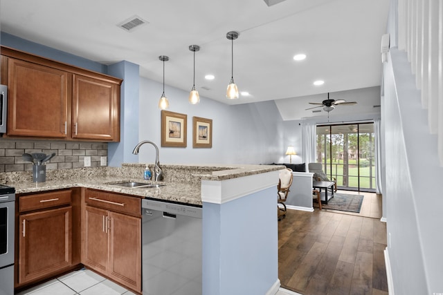 3833 Myrtle Pointe Dr Unit 18Bu 3, Myrtle Beach, SC 29577 - kitchen with stainless steel appliances, a sink, a peninsula, brown cabinets, and recessed lighting
