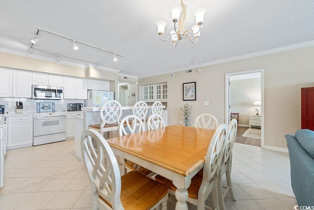 341 S Dunes Dr Unit C-34, Pawleys Island, SC 29585 - dining room featuring a chandelier, light tile patterned floors, ornamental molding, a textured ceiling, and rail lighting