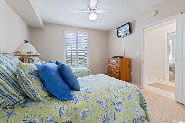341 S Dunes Dr Unit C-34, Pawleys Island, SC 29585 - bedroom with tile patterned flooring, carpet flooring, a ceiling fan, and a textured ceiling