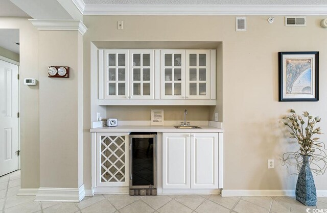 341 S Dunes Dr Unit C-34, Pawleys Island, SC 29585 - indoor wet bar with wine cooler, baseboards, ornamental molding, and light tile patterned floors