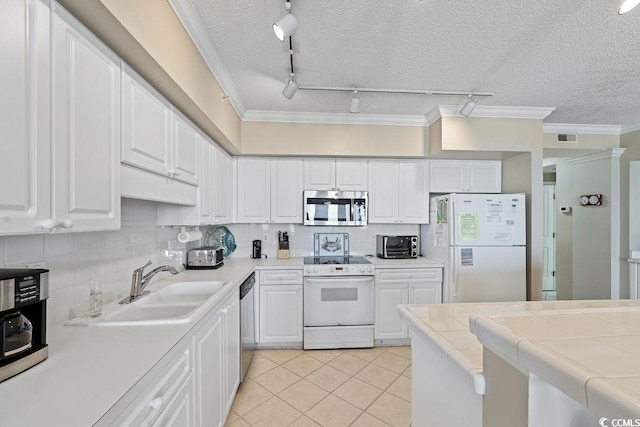 341 S Dunes Dr Unit C-34, Pawleys Island, SC 29585 - kitchen with stainless steel appliances, rail lighting, light tile patterned flooring, white cabinetry, and ornamental molding