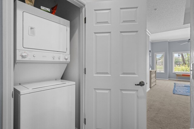 1551 Spinnaker Dr Unit 5312, North Myrtle Beach, SC 29582 - washroom featuring stacked washer / drying machine, light carpet, a textured ceiling, ornamental molding, and ceiling fan