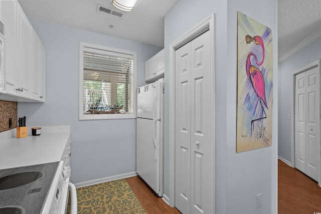 1551 Spinnaker Dr Unit 5312, North Myrtle Beach, SC 29582 - kitchen featuring freestanding refrigerator, white cabinetry, and dark wood finished floors