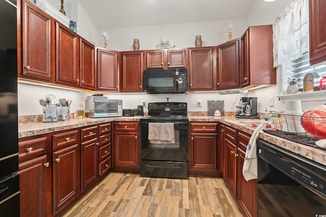 1068 Lizzie Ln, Surfside Beach, SC 29575 - kitchen featuring black appliances, reddish brown cabinets, light wood-style flooring, and light countertops