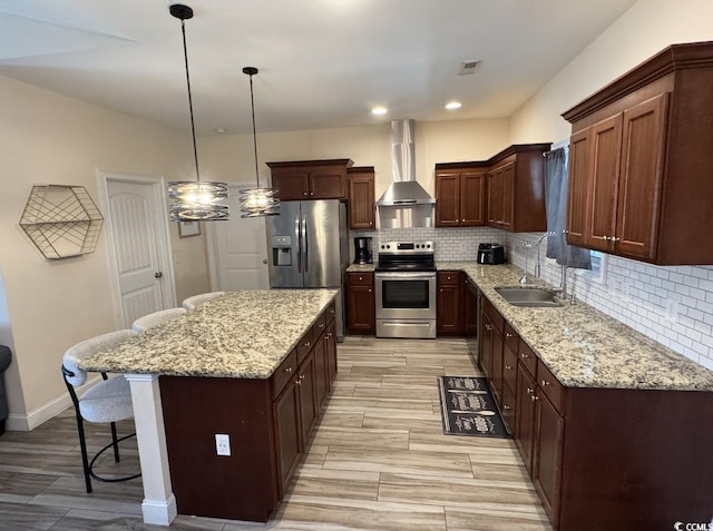 541 Irees Way, Longs, SC 29568 - kitchen featuring appliances with stainless steel finishes, wall chimney exhaust hood, a sink, a breakfast bar area, and decorative backsplash