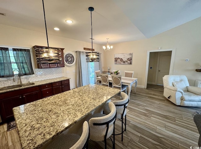 541 Irees Way, Longs, SC 29568 - kitchen with a sink, a chandelier, backsplash, light wood-type flooring, and light stone countertops