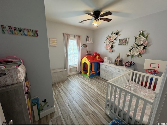 541 Irees Way, Longs, SC 29568 - bedroom with wood finished floors, a crib, ceiling fan, and baseboards