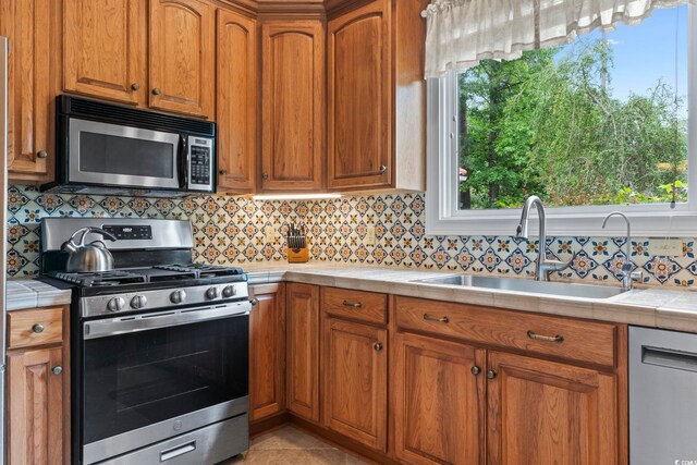 1501 Harbor Dr, North Myrtle Beach, SC 29582 - kitchen featuring stainless steel appliances, tile countertops, a sink, and backsplash