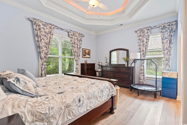 1501 Harbor Dr, North Myrtle Beach, SC 29582 - bedroom with multiple windows, light wood finished floors, a tray ceiling, crown molding, and ceiling fan
