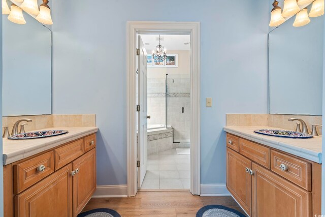 1501 Harbor Dr, North Myrtle Beach, SC 29582 - bathroom featuring a chandelier, decorative backsplash, baseboards, and two vanities