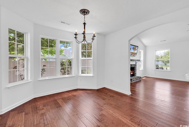 553 Fox Chase Dr, Conway, SC 29527 - unfurnished dining area with arched walkways, a brick fireplace, a chandelier, hardwood / wood-style flooring, and baseboards