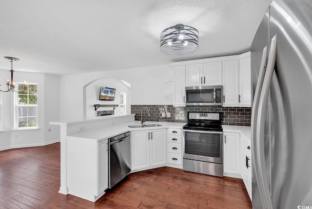 553 Fox Chase Dr, Conway, SC 29527 - kitchen with stainless steel appliances, a sink, a peninsula, white cabinetry, and a textured ceiling