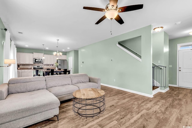 408 Carmello Cir, Conway, SC 29526 - living room featuring light wood-type flooring, a chandelier, a ceiling fan, stairs, and recessed lighting