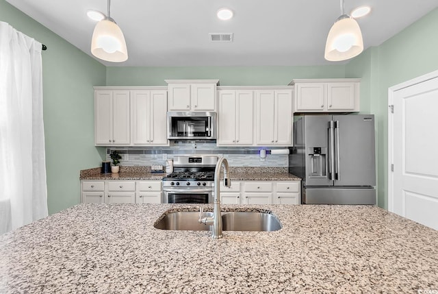 408 Carmello Cir, Conway, SC 29526 - kitchen with appliances with stainless steel finishes, a sink, white cabinets, backsplash, and light stone countertops
