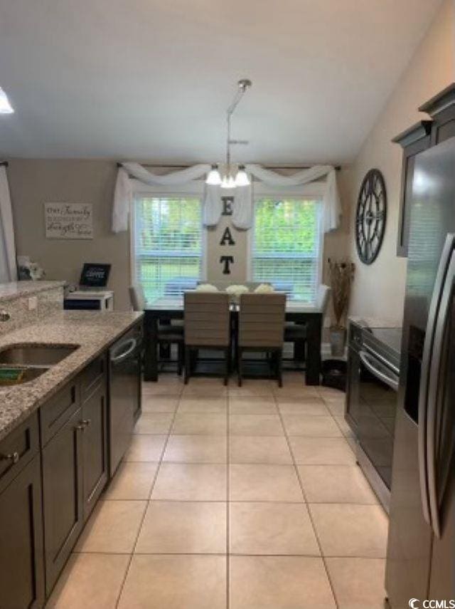 387 Blue Rock Dr, Longs, SC 29568 - kitchen featuring appliances with stainless steel finishes, a chandelier, light tile patterned flooring, a sink, and light stone counters