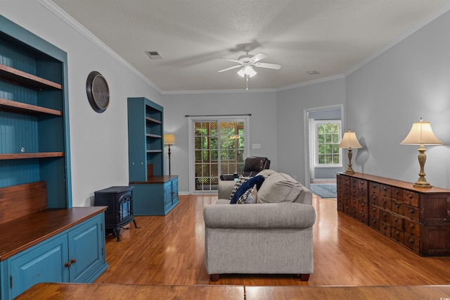 100 Lazy Willow Ln Unit 103, Myrtle Beach, SC 29588 - living area featuring a wood stove, a ceiling fan, wood finished floors, and crown molding