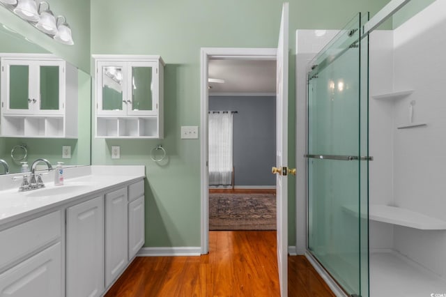 100 Lazy Willow Ln Unit 103, Myrtle Beach, SC 29588 - bathroom featuring wood finished floors, vanity, baseboards, an enclosed shower, and crown molding