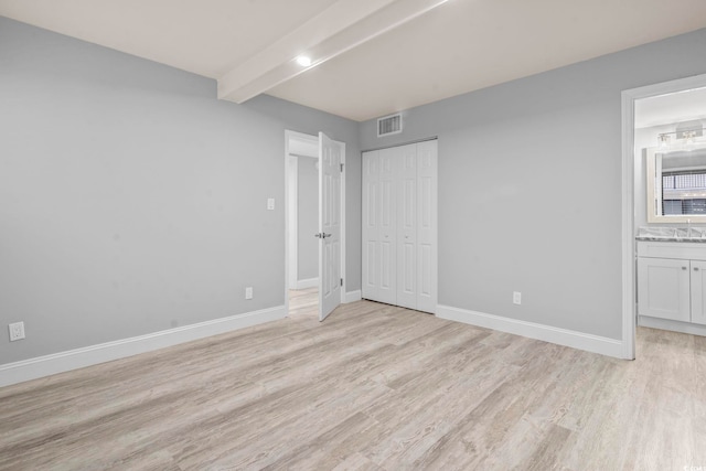 601 Mitchell Dr Unit 207, Myrtle Beach, SC 29577 - unfurnished bedroom featuring light wood-style flooring, beamed ceiling, ensuite bath, and a closet