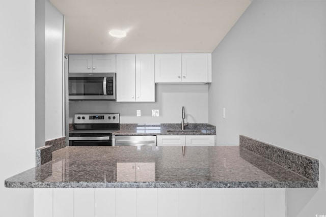 601 Mitchell Dr Unit 207, Myrtle Beach, SC 29577 - kitchen with stainless steel appliances, a peninsula, white cabinetry, and dark stone countertops