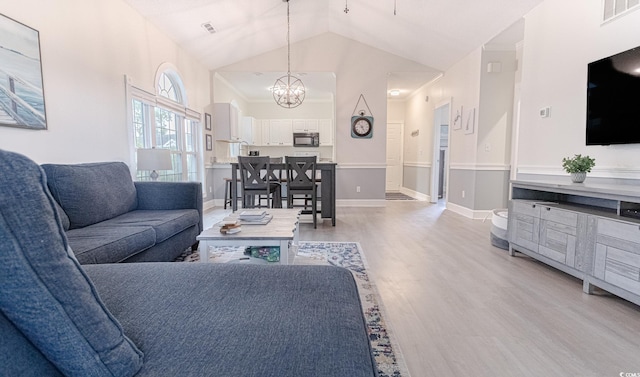 698 Riverwalk Dr Unit 304, Myrtle Beach, SC 29579 - living area featuring light wood finished floors, a chandelier, baseboards, and lofted ceiling