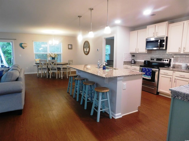 401 Quinta St, Longs, SC 29568 - kitchen with appliances with stainless steel finishes, dark wood-style flooring, light stone countertops, and white cabinetry