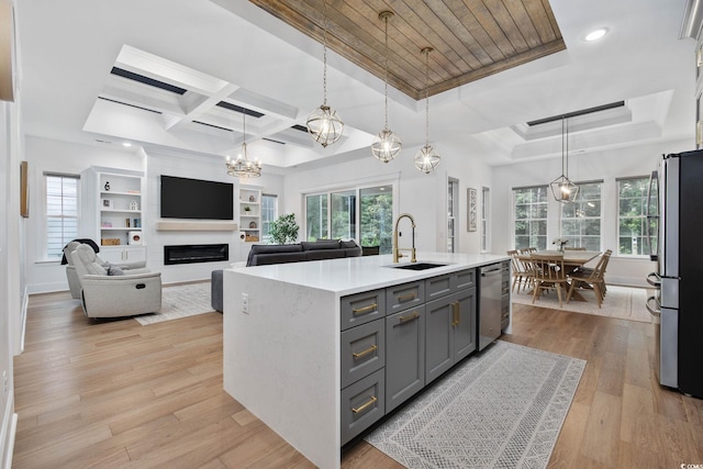 1058 E Isle Of Palms Ave, Myrtle Beach, SC 29579 - kitchen with appliances with stainless steel finishes, gray cabinetry, a glass covered fireplace, light countertops, and a chandelier