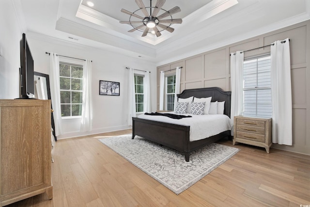 1058 E Isle Of Palms Ave, Myrtle Beach, SC 29579 - bedroom featuring ornamental molding, light wood-style flooring, a tray ceiling, and ceiling fan