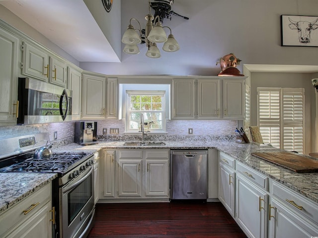 1635 Southwood Dr, Surfside Beach, SC 29575 - kitchen with appliances with stainless steel finishes, dark wood-style flooring, light stone counters, tasteful backsplash, and a chandelier