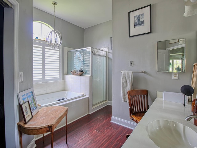 1635 Southwood Dr, Surfside Beach, SC 29575 - full bathroom featuring a chandelier, a bath, wood finished floors, a stall shower, and double vanity