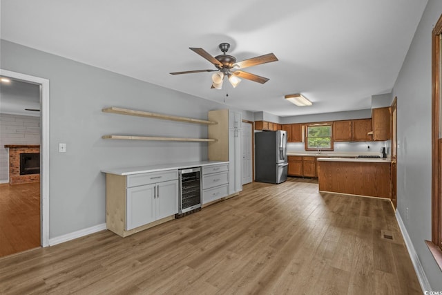 124 Wicklow Way, Pawleys Island, SC 29585 - kitchen with stainless steel refrigerator with ice dispenser, wine cooler, brown cabinetry, a ceiling fan, and light wood-style floors
