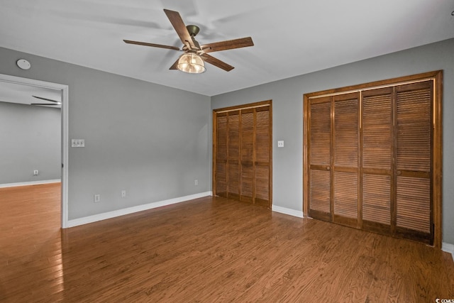 124 Wicklow Way, Pawleys Island, SC 29585 - unfurnished bedroom with two closets, wood finished floors, baseboards, and a ceiling fan