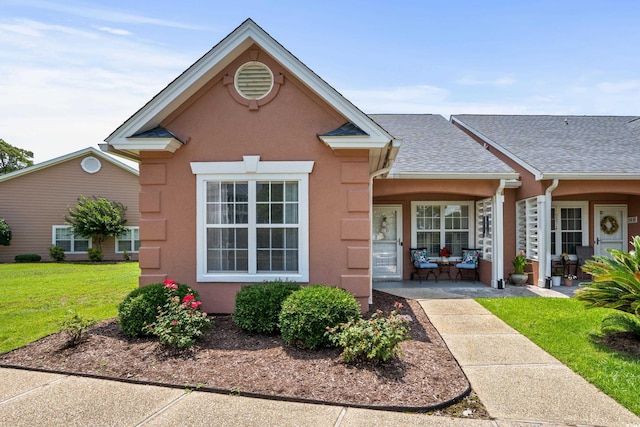 4648 Lightkeepers Way Unit 39A, Little River, SC 29566 - view of front of house with stucco siding, a front lawn, and roof with shingles